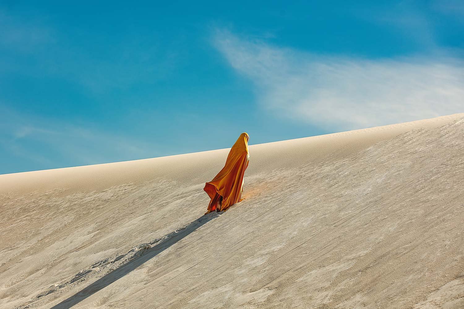 woman-in-yellow-arabic-clothing-climbing-a-dune-in-2026-03-09-07-10-30-utc.jpg